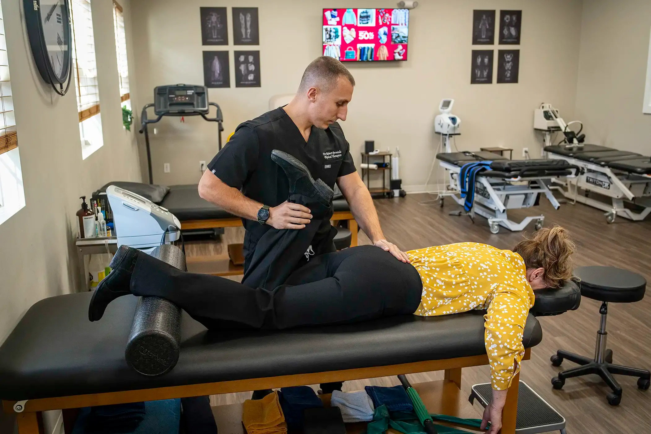 Physical therapist guiding an older patient through flexion-based exercises for spinal stenosis relief in Morganville, NJ